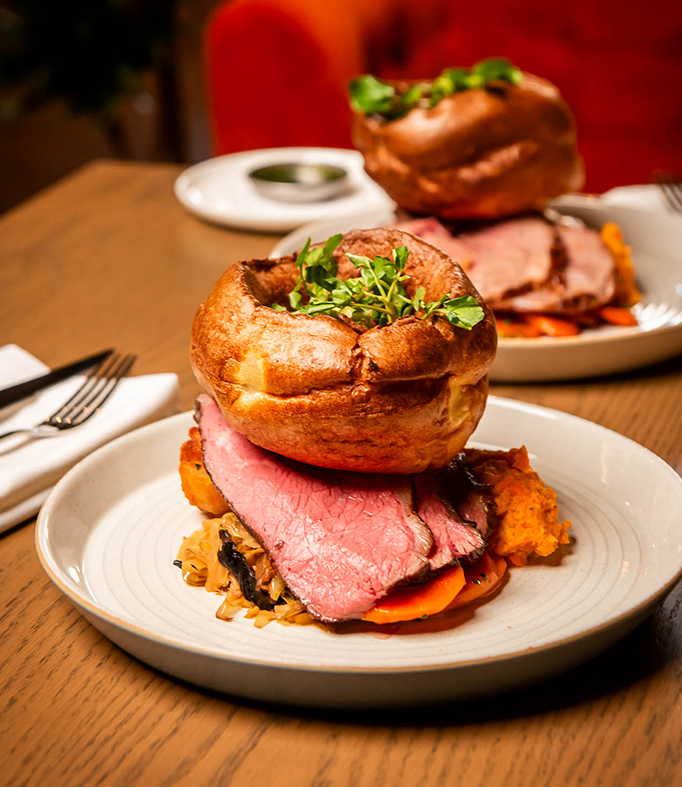 Sunday Roast on wooden table with giant yorkshire pudding